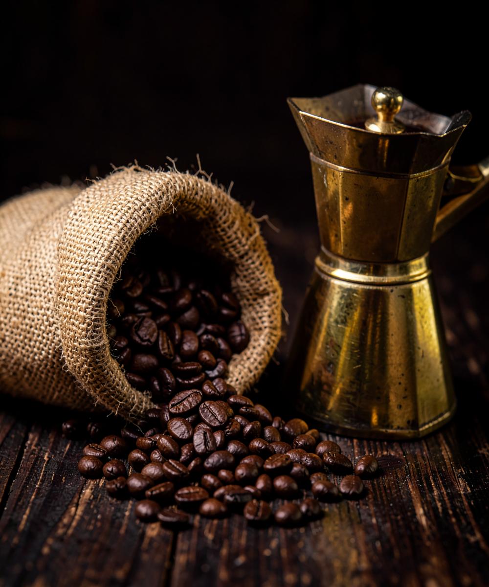 Roasted coffee beans and a brass moka pot